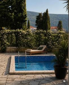 a swimming pool with a bench and a couch next to at Sun House in Kumbor
