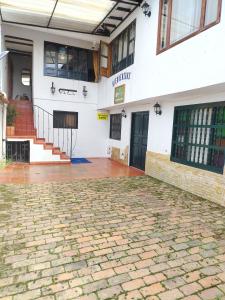 a building with a cobblestone courtyard in front of it at Hospedería Villa Lucía in Villa de Leyva