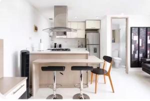 a kitchen with two bar stools and a counter top at Loft Premium El Poblado in Envigado