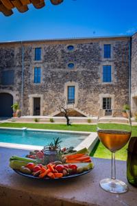 a plate of vegetables and a glass of wine on a table at Domaine Croix-Maro in Caux