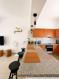 a kitchen with a large counter with chairs and tables at Jasmine House Egkomi in İncirli