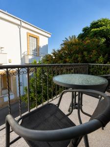 a table and a chair sitting on a balcony at Jasmine House Egkomi in İncirli