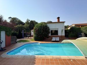 a swimming pool in front of a house at Cal Piano in Palol de Rebardit