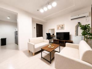 a living room with white furniture and a flat screen tv at Excel 琴似 -FIX HOME- in Sapporo