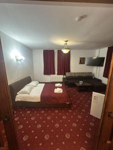 a hotel room with a bed and a couch at Pensiunea Panoramic - Transalpina Rânca in Ranca +56 photos