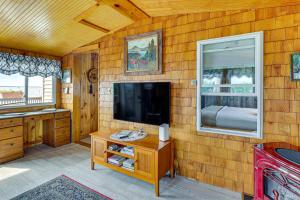 a room with a flat screen tv and a table at Sunset Views & Deck: Lake Champlain Cottage! in Swanton