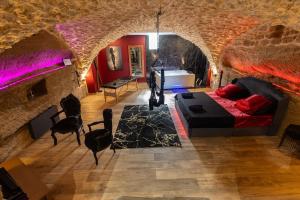 a living room with a bed and a stone wall at l'Envoûtée, suite de charme in Sérignan-du-Comtat
