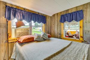 a bedroom with a bed and a window at Sunset Views & Deck: Lake Champlain Cottage! in Swanton