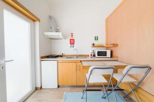 a small kitchen with two chairs and a sink at Pátio Mariano in Serra de El-Rei +56 photos