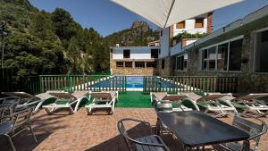 a patio with tables and chairs and a swimming pool at Hotel Spa Venta Ticiano in Yeste