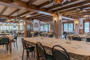a dining room with tables and chairs and exposed ceilings at Hotel Spa Venta Ticiano in Yeste