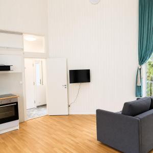a living room with a couch and a tv on the wall at Bokloster Longstay in Märsta +5 photos