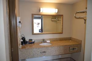 a bathroom with a sink and a mirror at Regency Inn in Chickasha