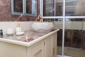 a bathroom with a marble sink and a glass shower at Middleham Forest Nook in Roseau +14 photos