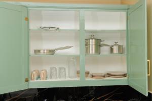 a green cabinet with dishes and pots and pans at Middleham Forest Nook in Roseau