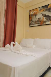 a white bed with towels on it in a room at Middleham Forest Nook in Roseau