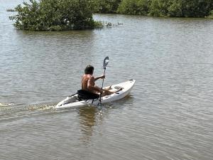 a man sitting on a kayak in the water at Tanema Creek in Brufut