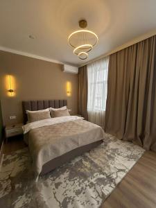 a bedroom with a large bed and a large window at Verde Hotel in Semey