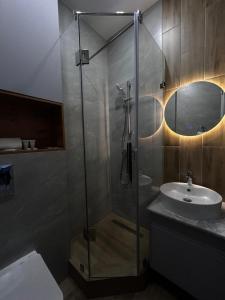 a bathroom with a glass shower and a sink at Verde Hotel in Semey +8 photos