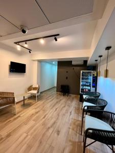 a room with tables and chairs and a tv on the wall at Rooms&Go by LAtic in Alicante