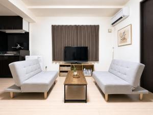a living room with two chairs and a tv at Excel 美園 -FIX HOME- in Sapporo