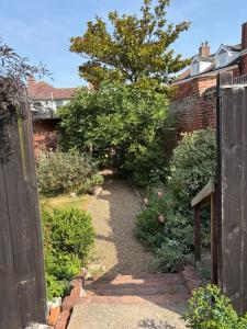 a garden with a brick wall and a pathway at River Garden View in Beccles
