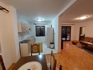 a kitchen and living room with a table and a refrigerator at PEKOVIĆ in Bar