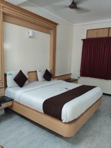 a large bed in a room with a large window at Hotel ESS Paradise in Coimbatore