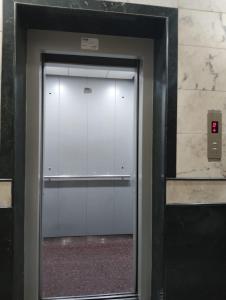 a elevator door in a building with a red light at Hotel ESS Paradise in Coimbatore