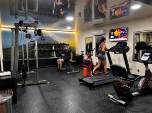 a woman exercising on a treadmill in a gym at Urban Green Hotel & Suites in San José +47 photos