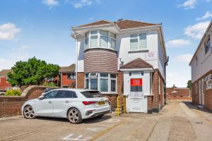 a white car parked in front of a house at 2 Bed Flat 10mins Heathrow 1 Parking EV in Hanworth