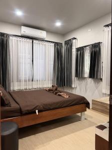 a bedroom with a bed in a room with windows at CS phangan Villa in Ko Phangan
