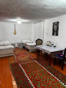 a living room with a table and a couch at Nazik Guest House in Barskoon