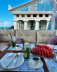 a table with plates of food and drinks on it at Orbi City Panorama Hotel & Sea View Balcony in Batumi