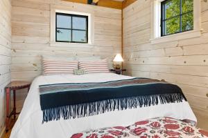 a bedroom with a bed in a log cabin at Aril Cottage-Waterfront Escape with Ocean Views in Gouldsboro