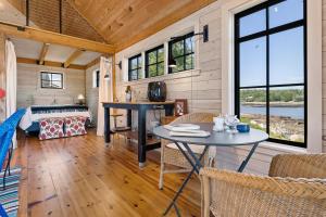 a room with a bed and a table and chairs at Aril Cottage-Waterfront Escape with Ocean Views in Gouldsboro