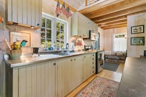 a kitchen with white cabinets and an american flag at The Boathouse in Brighams Cove +41 photos