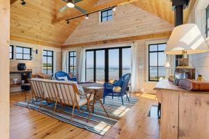 a living room with a table and chairs in a cabin at Aril Cottage-Waterfront Escape with Ocean Views in Gouldsboro +20 photos