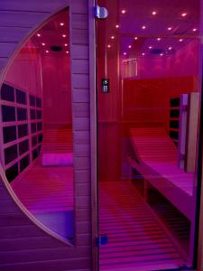 a pink room with a mirror and red stairs at LA BÂTISSE l'arbre beige in Le Petit-Abergement