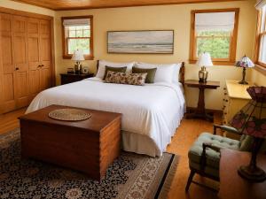 a bedroom with a bed and a table and a couch at Capstone Cottage - Quintessential Cabin on Bay in Gouldsboro
