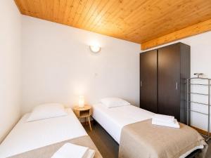 a bedroom with two beds and a table with a lamp at Le Condrieu in Vérin