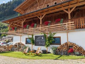 a building with a table and chairs in front of it at Greiterhof Partschins in Parcines