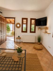 a living room with a flat screen tv on the wall at Madona Casas in Psilá Alónia