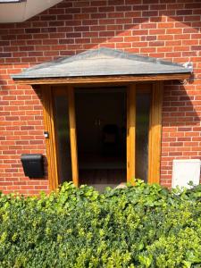 a front door of a brick building with a roof at River Garden View in Beccles