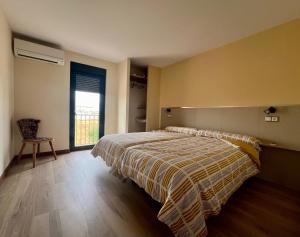 a bedroom with a bed and a window and a chair at El Refugio de Pedrosa in Pedrosa del Rey