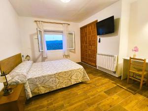 a bedroom with a bed and a window and a desk at Alojamientos El Pardal in Molinicos
