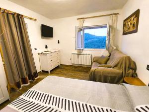a bedroom with a bed and a couch and a window at Alojamientos El Pardal in Molinicos