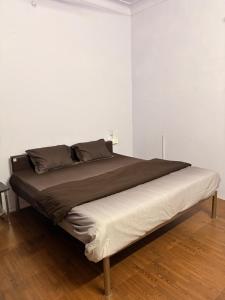a bed in a room with a white wall at Vyom Hostel in Pushkar