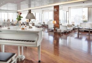 a white piano in the middle of a living room at Hotel Ascot & Spa in Rimini