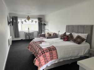 a bedroom with a large bed and a window at Traeth Rooms in Cardigan